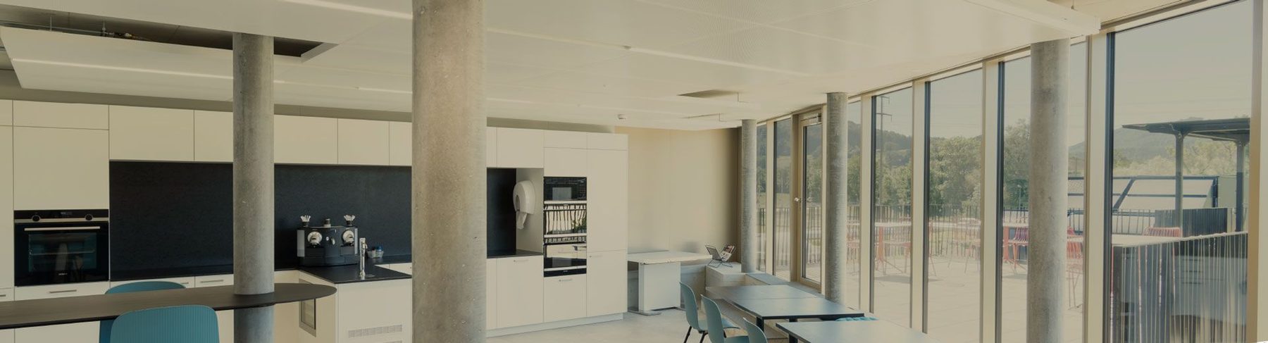 L'espace commun des locaux de Steulet Microtechnique, baies vitrées sur la campagne